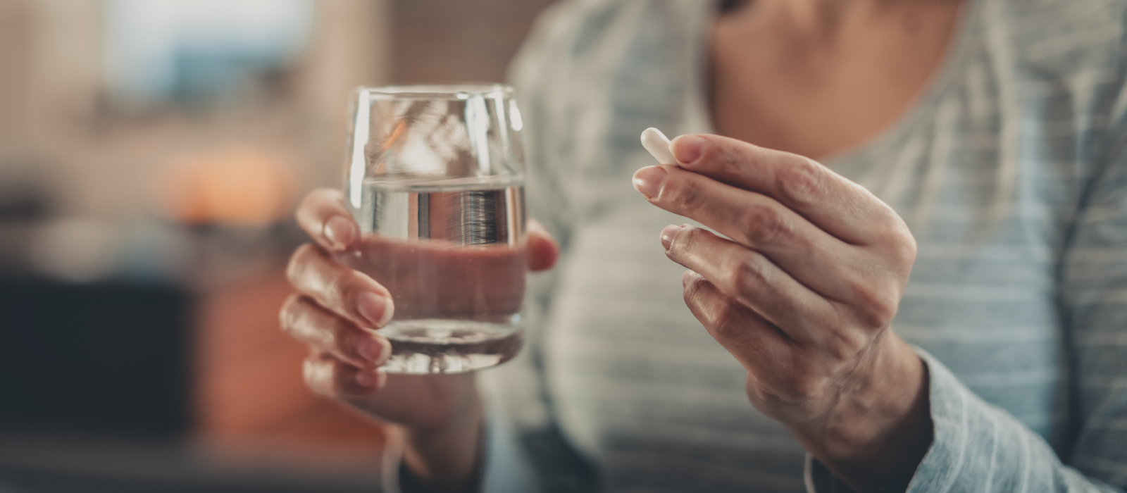 Woman with pill and glass of water